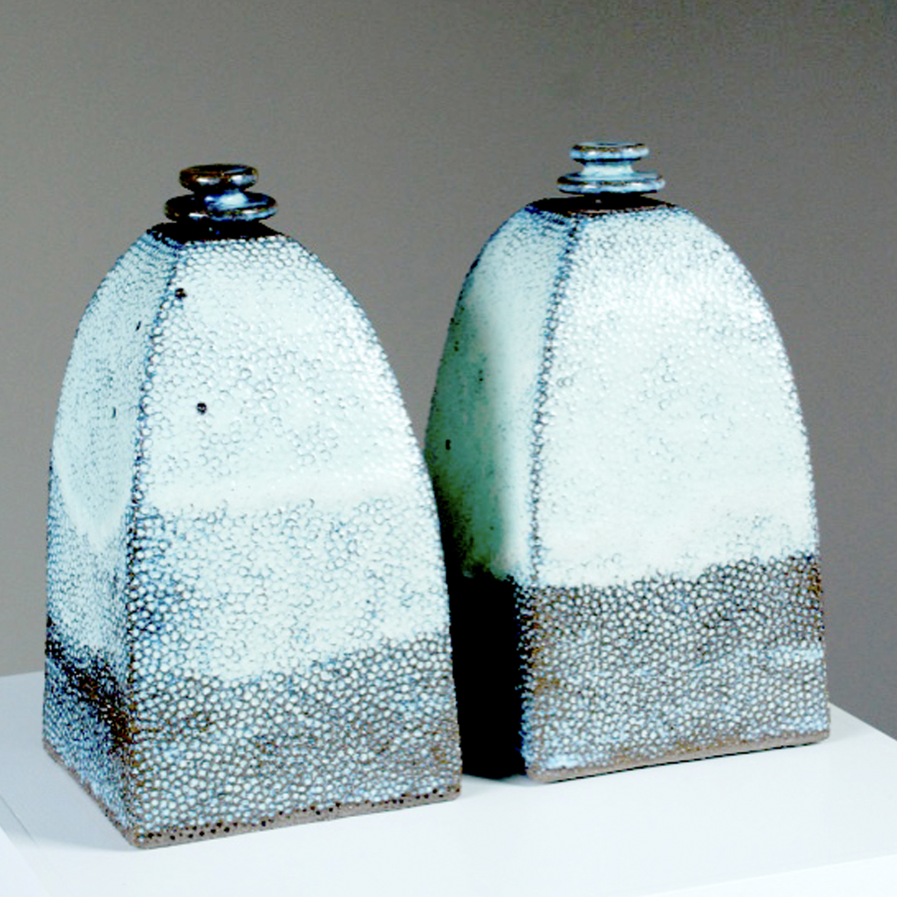 i-POtS — twee vierzijdige sculpturen met stippenreliëf in ijsblauw en grijs